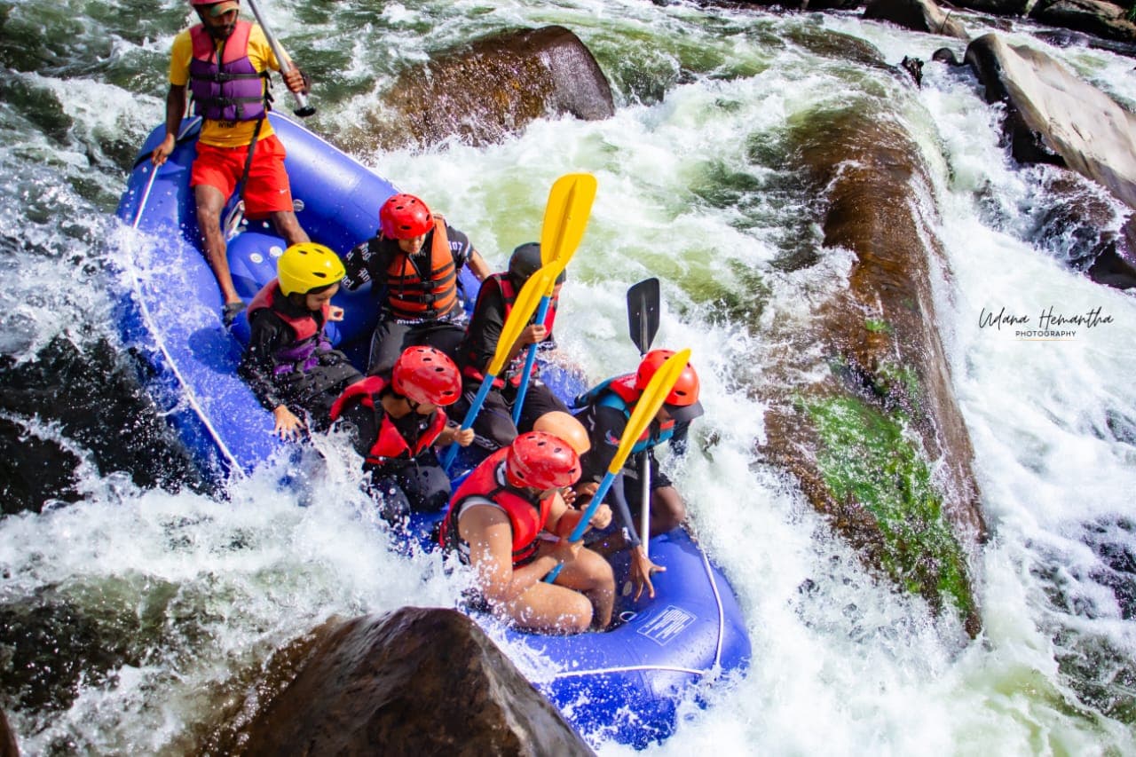 Two rafts hitting the same wave together on the Kelani River, throwing up a wall of white water